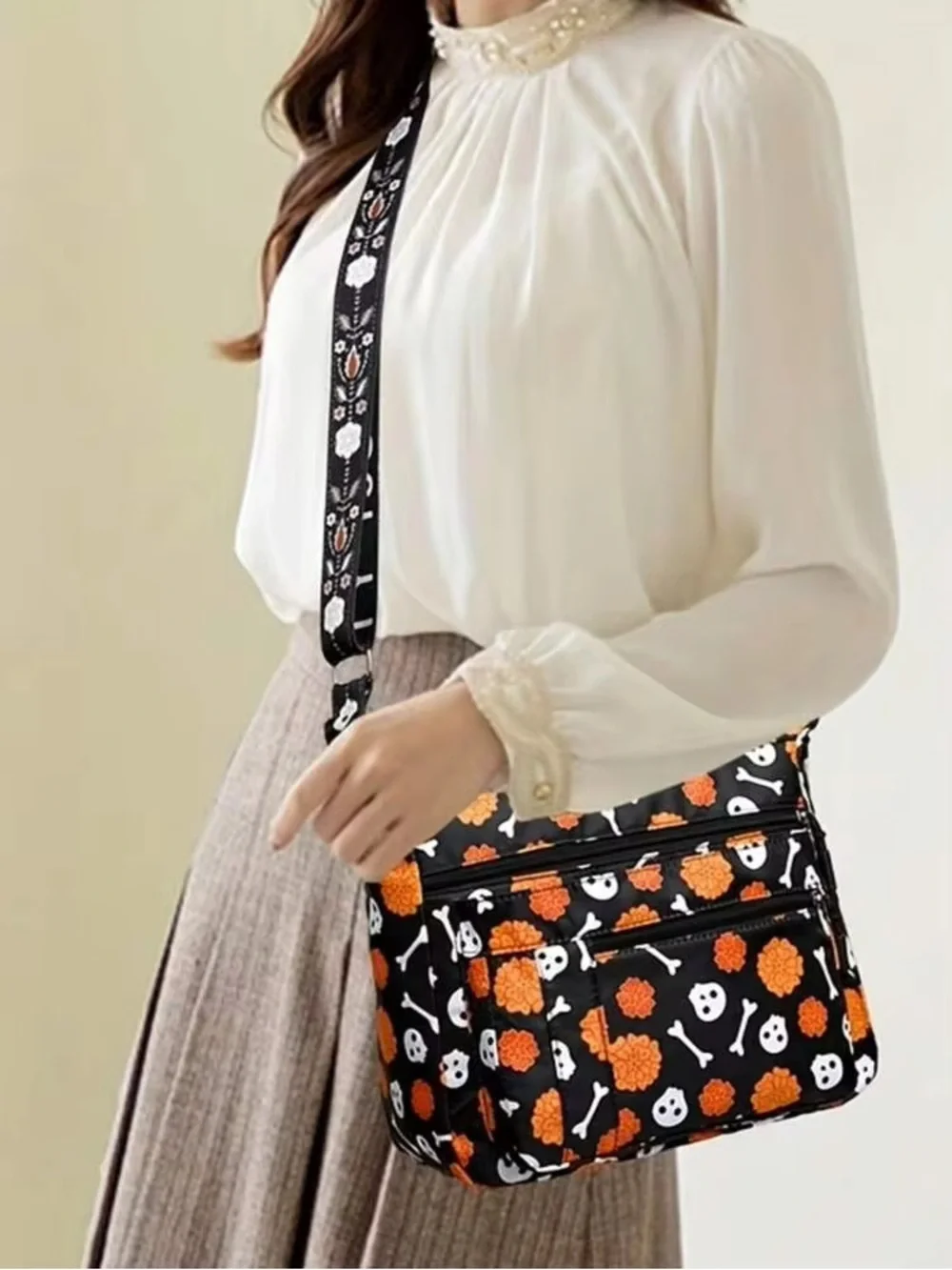 Halloween-themed crossbody bag featuring a skull and marigold print